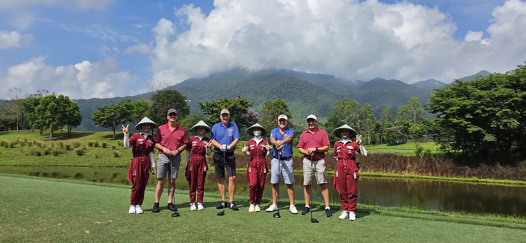 The Gold Corp crew with their caddies on the tee at Ba Na Hills, mountains in the background